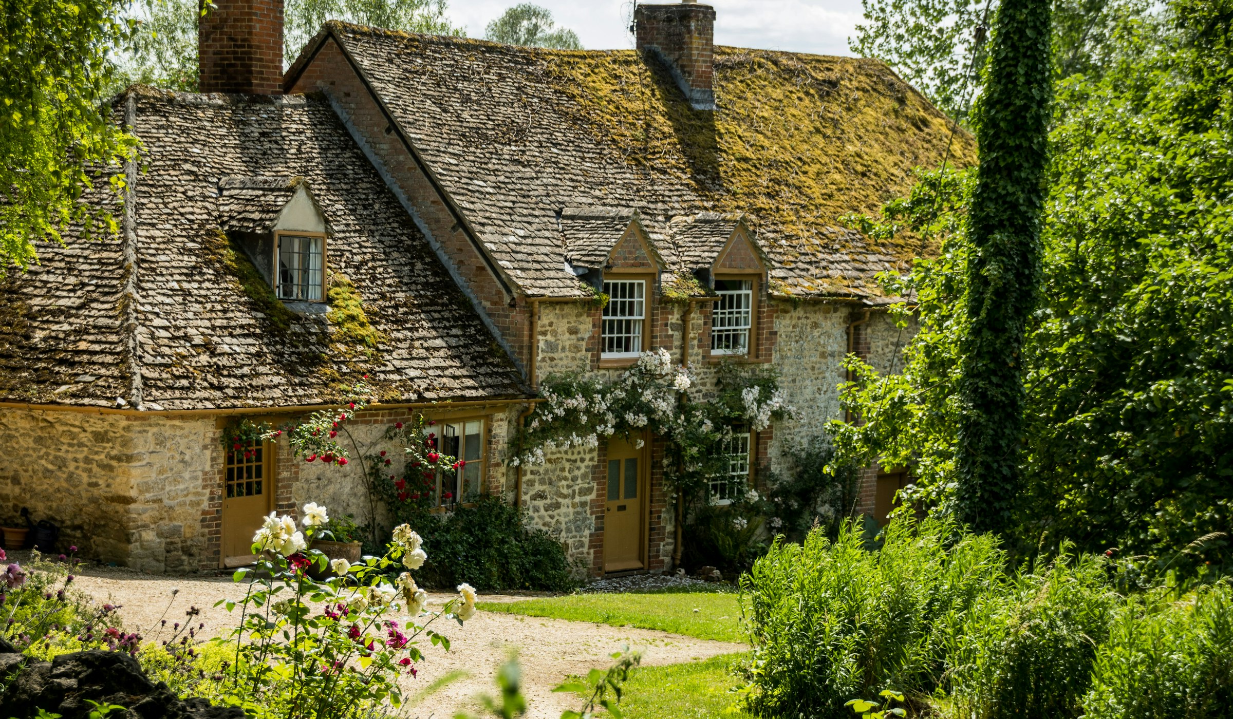 A finished cottage garden with stone patio and lush planting in the South West of England
